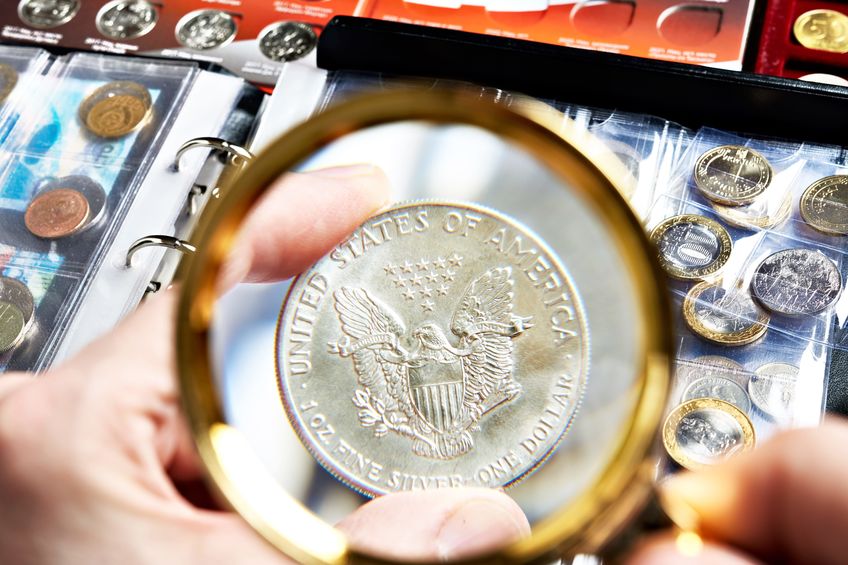 An American coin being examined under a magnifying class